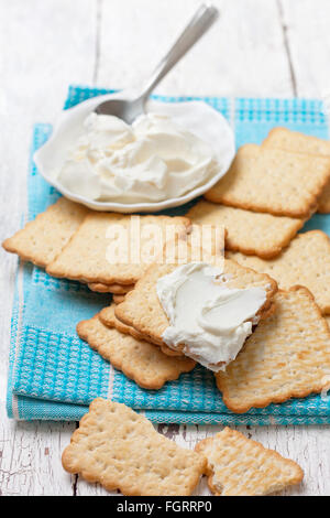 light snack of crackers and cream cheese on blue napkin on Stock Photo