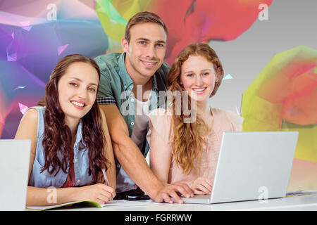 Composite image of fashion students using laptop Stock Photo