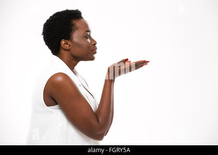 Profile of charming african american young woman sending a kiss over white background Stock Photo