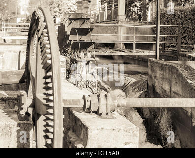 Old iron wheel a watermill. Ruins of a watermill. Stock Photo