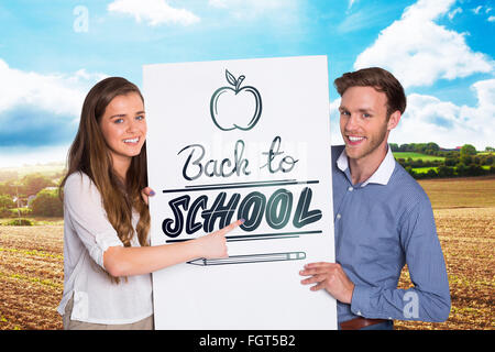 Composite image of happy young couple with blank board Stock Photo