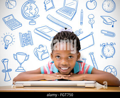 Composite image of smiling pupil sitting at her desk Stock Photo