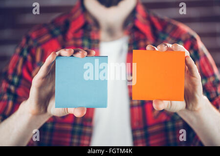 Man showing orange and blue adhesive notes Stock Photo