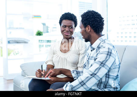 Man talking with pregnant wife while pointing on paper Stock Photo