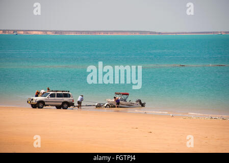 Launching a boat on a beach facing Roebuck Bay. It  is close to the Port of Broome in Broome, a coastal, pearling and tourist to Stock Photo