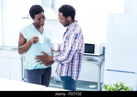 Man touching wife belly while having coffee Stock Photo