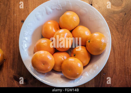 Mandarin oranges, Citrus reticulata, in a white bowl. Shot from above. Stock Photo