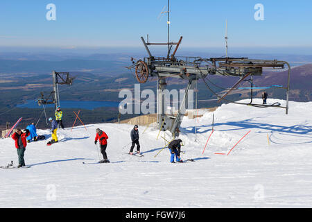 Skiers and snow boarders at top of T-bar lift at Cairngorm Mountain Ski Centre, Aviemore, Scottish Highlands, UK Stock Photo