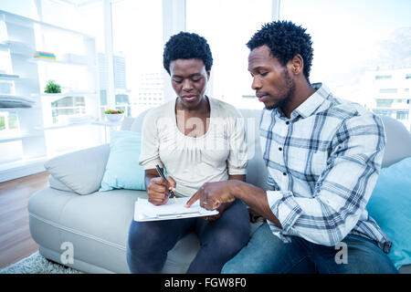 Man pointing on notepad while talking with pregnant wife Stock Photo