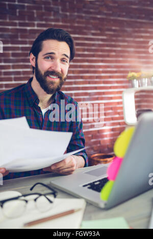 Portrait of smiling creative businessman with documents Stock Photo