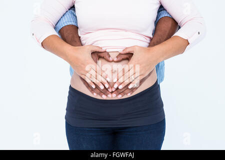 Midsection of couple making heart shape on belly Stock Photo