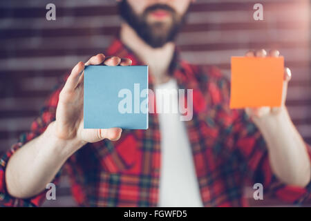 Man holding orange and blue adhesive notes Stock Photo