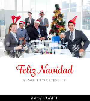 Composite image of portrait of a smiling business team wearing novelty christmas hat Stock Photo