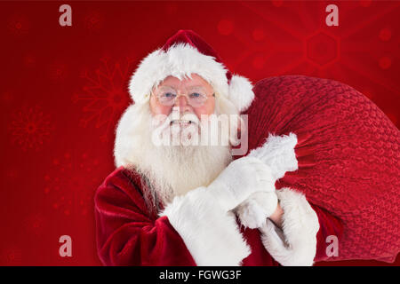 Composite image of jolly santa carries his sack Stock Photo