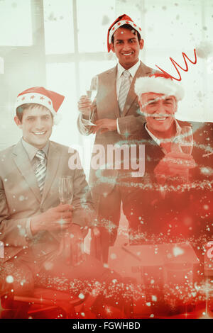 Composite image of confident businessmen wearing novelty christmas hat Stock Photo