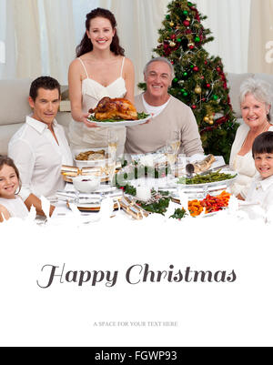 Composite image of family celebrating christmas dinner with turkey Stock Photo