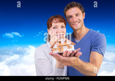 Composite image of couple holding a model house Stock Photo