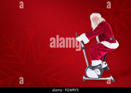 Composite image of santa uses a home trainer Stock Photo