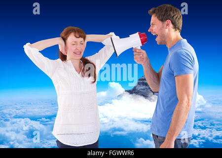 Composite image of man shouting through a megaphone Stock Photo