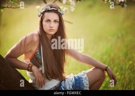 Beautiful hippie woman leaning on a tree . Nature and peace Stock Photo