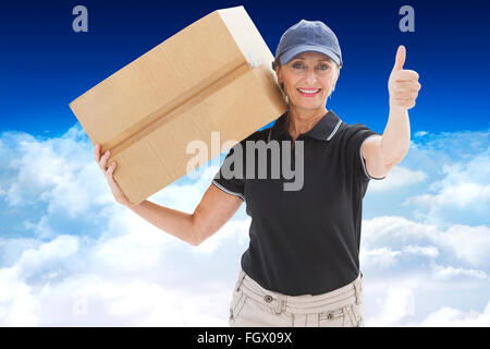 Composite image of happy delivery woman holding cardboard box Stock Photo