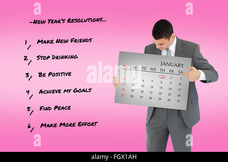 Composite image of businessman pointing at calendar in his hands Stock Photo