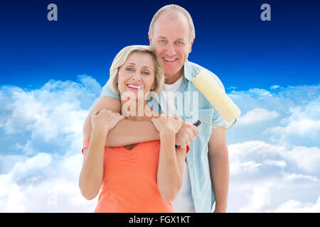 Composite image of happy older couple holding paint roller Stock Photo