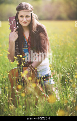 Beautiful hippie woman posing with guitar . Nature harmony Stock Photo