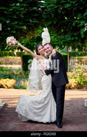 bride and groom walking in the park on their wedding day Stock Photo