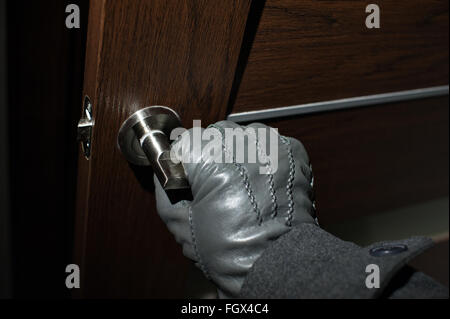 man's hand in a black glove opening the door Stock Photo