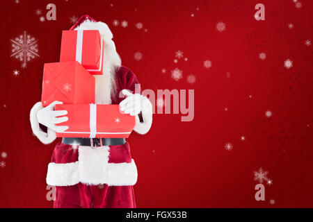 Composite image of santa covers his face with presents Stock Photo