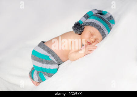 newborn baby sleeps in a knit suit on a white background Stock Photo