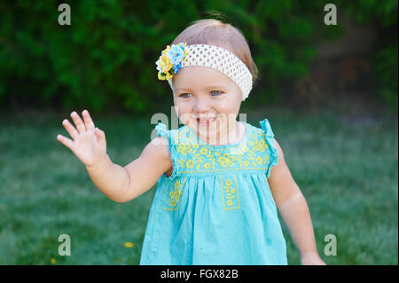 little girl walks in the park on the grass Stock Photo