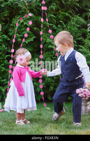 little boy walking with girl in the summer park Stock Photo