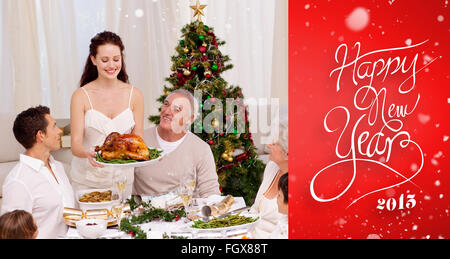 Composite image of mother showing turkey to her family for christmas Stock Photo