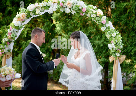 bride groom dresses a ring on a finger at a wedding ceremony Stock Photo