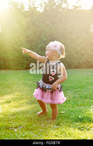 Happy Little girl playing in summer meadow on grass Stock Photo