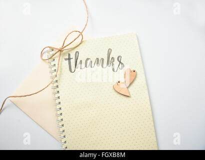 Postcard with the words thanks on a paper background with two hearts Stock Photo