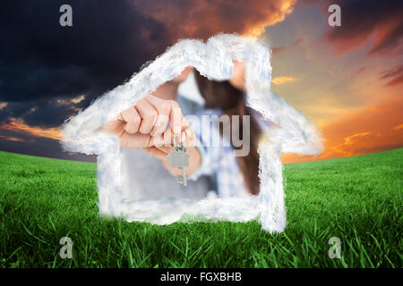 Composite image of man and wife presenting a key with a house keychain Stock Photo