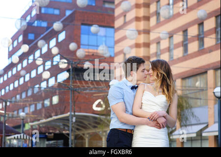 Bride and groom walking around among the houses buildings Stock Photo