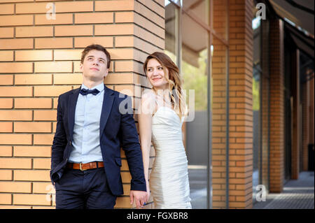 Bride and groom walking around among the houses buildings Stock Photo