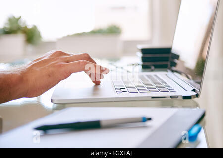 Hand busy operating the touchpad on a laptop Stock Photo