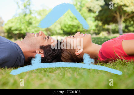 Composite image of two friends looking upwards while lying head to head Stock Photo