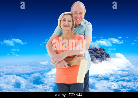 Composite image of happy older couple holding paint roller Stock Photo