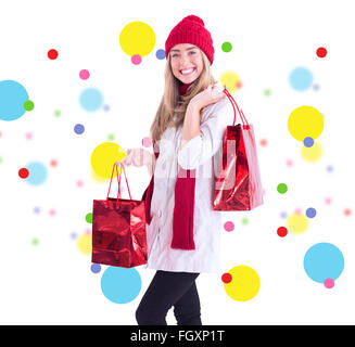 Composite image of pretty blonde holding shopping bags Stock Photo