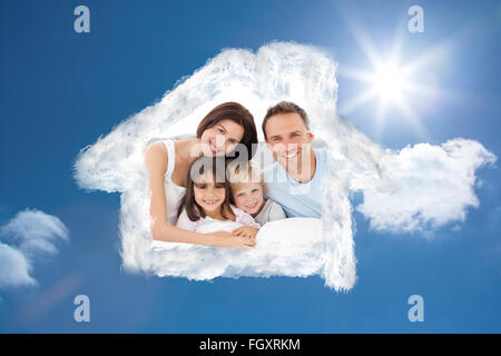 Composite image of lovely family sitting together on the bed Stock Photo