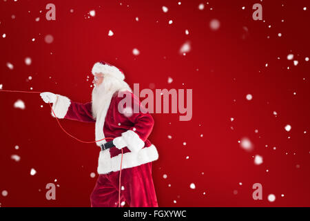 Composite image of santa pulls something with a rope Stock Photo