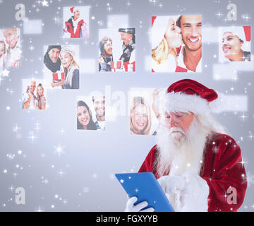 Composite image of santa uses a tablet pc Stock Photo