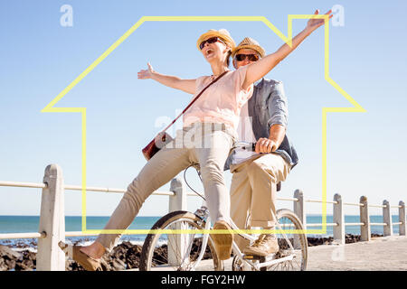Composite image of happy casual couple going for a bike ride on the pier Stock Photo