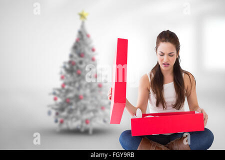 Composite image of unhappy brunette opening present Stock Photo